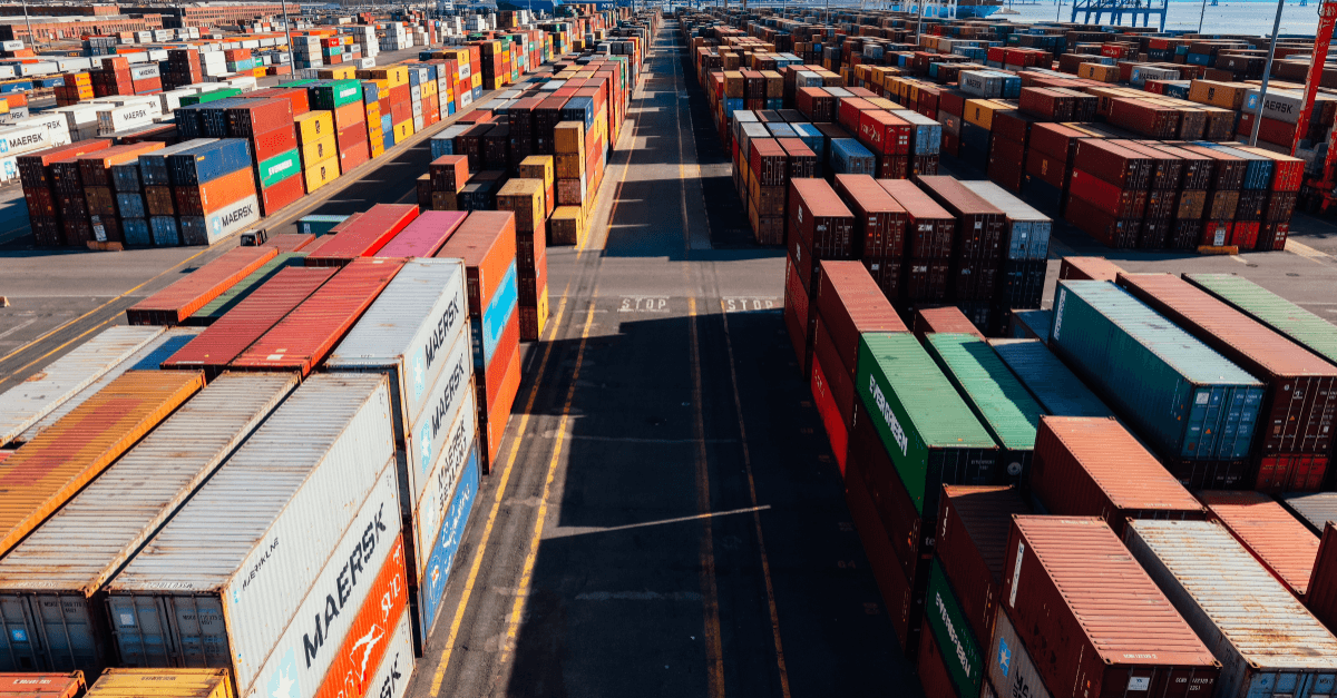 Aerial view of a shipping container terminal with stacked Maersk and Evergreen containers representing GCC-to-India supplier trade